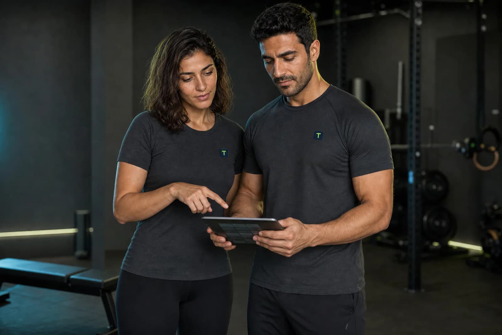 TrainPact's fictional female and male brand models reviewing a training plan together on a tablet