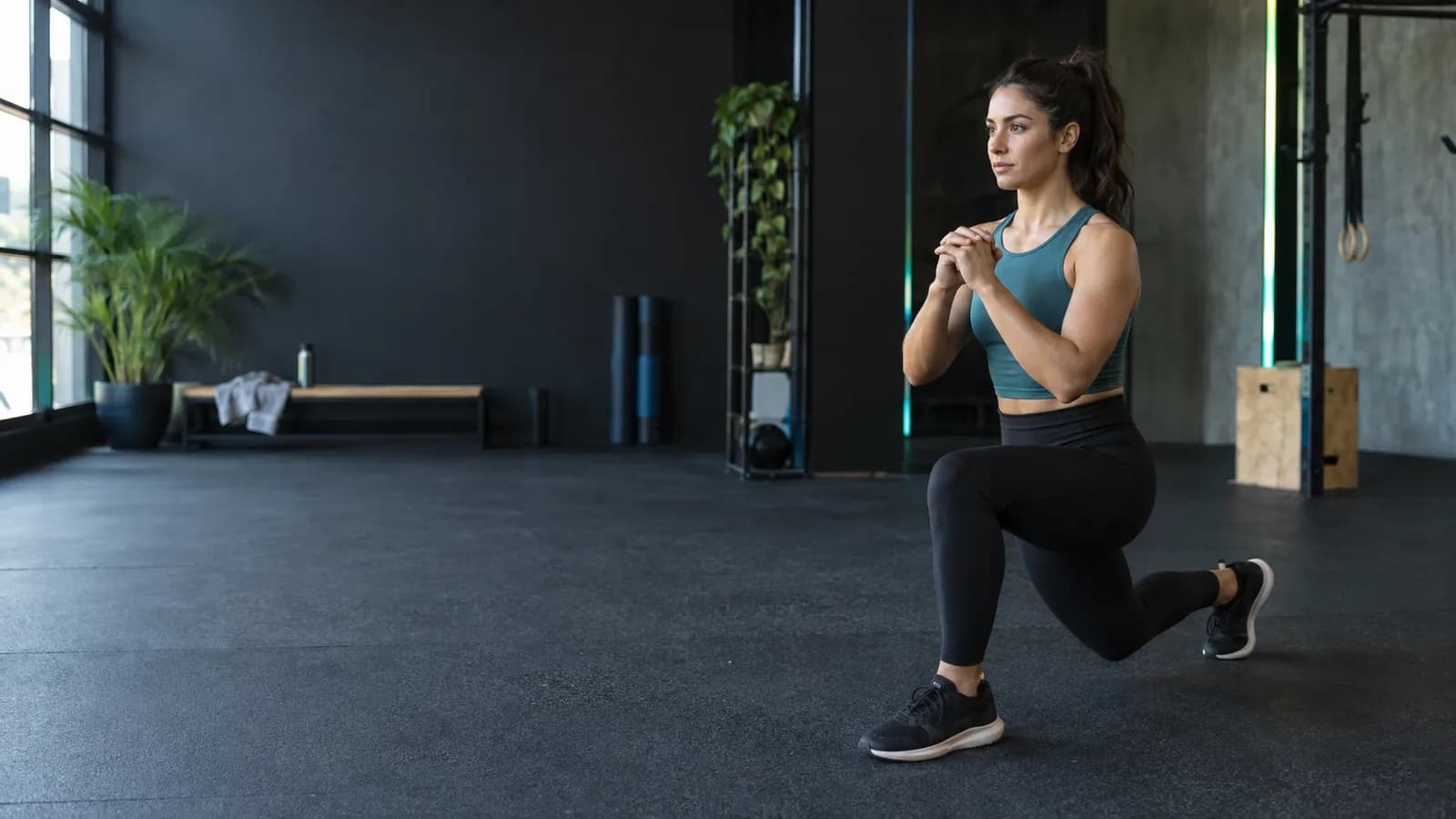 Spor salonunda ekipmansız kontrollü geri hamleyle ısınan yetişkin sporcu